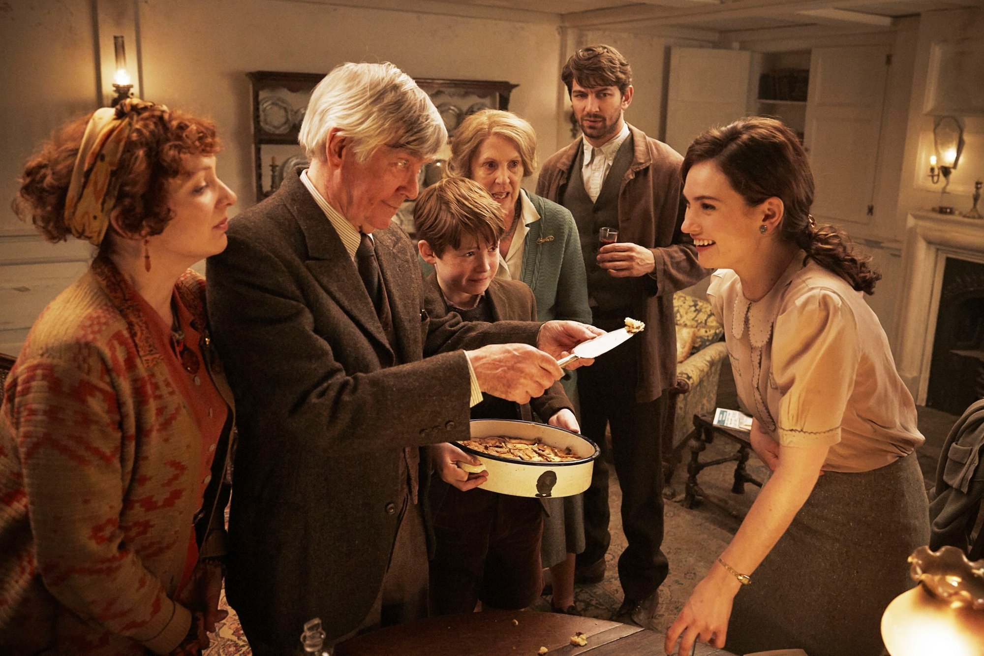 Katherine Parkinson, Tom Courtenay, Kit Connor, Penelope Wilton, Michiel Huisman and Lily James in Netflix's The Guernsey Literary and Potato Peel Pie Society (2018)